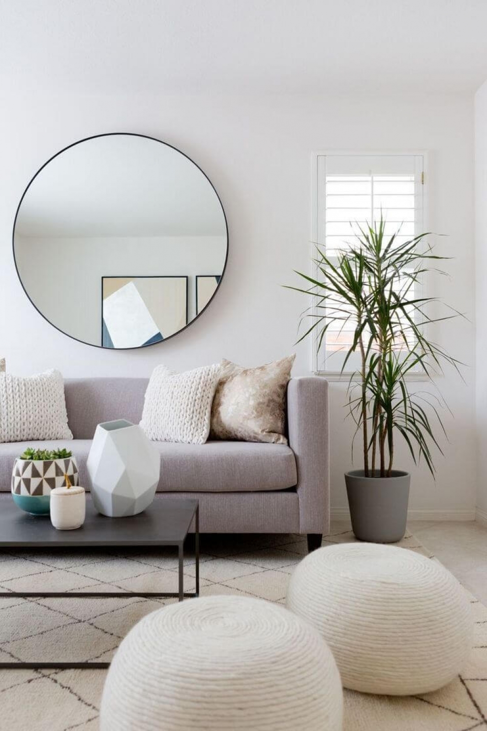 round mirror above sofa